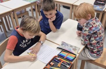 Učenec z roko piše na list papirja.