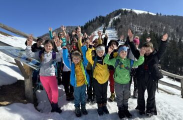Mladi planinci pri koči pod Blegošem, v ozadju vrh Blegoša