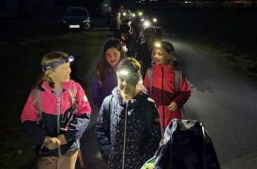 Otroci s čelnimi lučkami na večernem pohodu