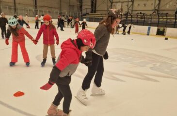 Otroci drsajo v ledeni dvorani.