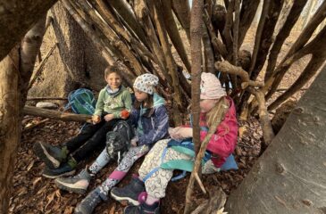 Učenci malicajo v bivaku, ki so ga zgradili sami.