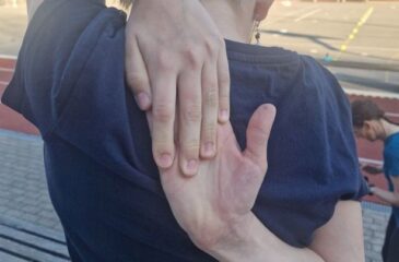 Dekle s sklenjenimi rokami na hrbtu